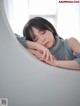 A woman laying on top of a white chair with her eyes closed.