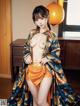 A woman in a blue and orange kimono posing for the camera.